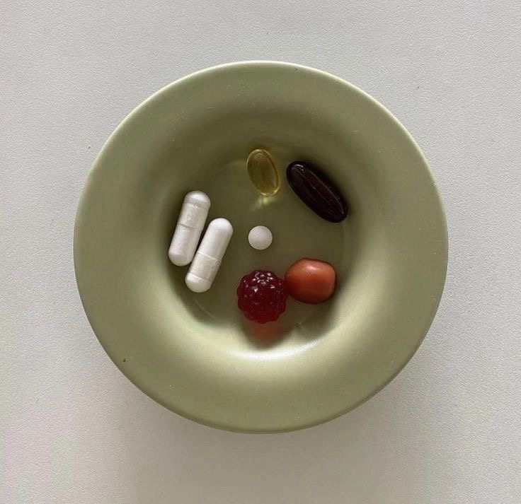 Imagem de estilo Instagram mostrando suplementos variados organizados em um recipiente, representando a estética do bem-estar e o consumo diário na rotina da geração Z